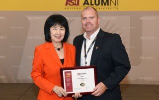 Eric Olsen receives his award from ASU Alumni Association President Christine Wilkinson.