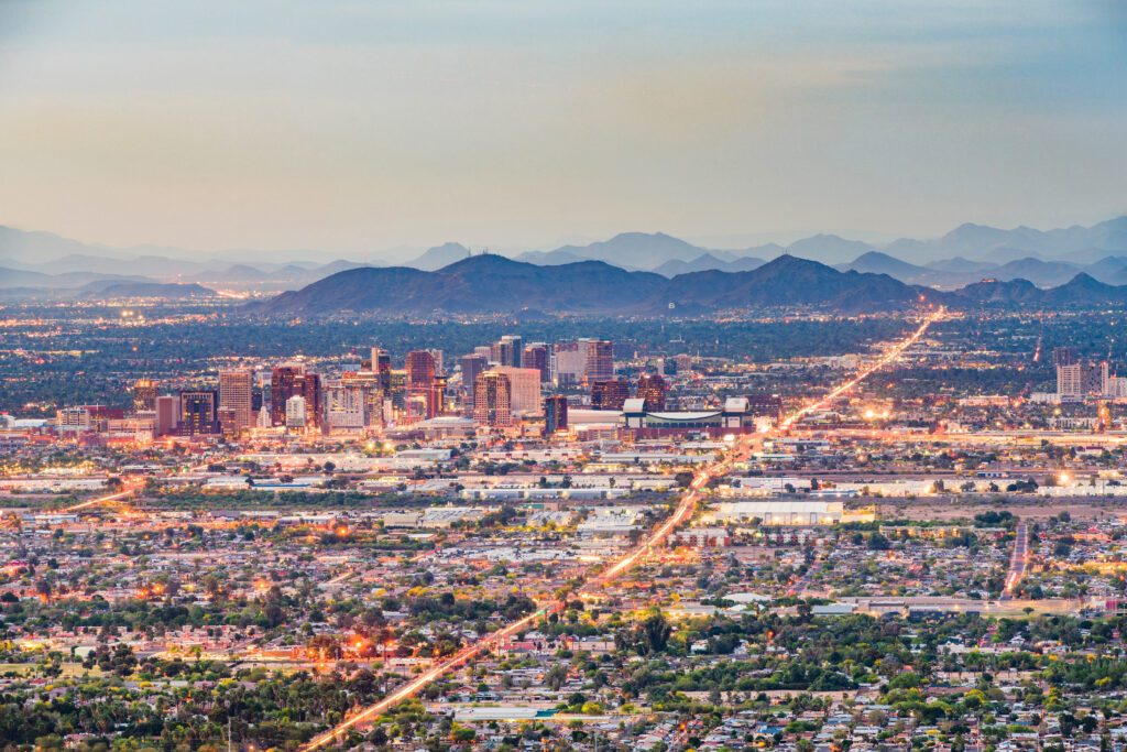 Phoenix skyline at dusk with city lights and mountains