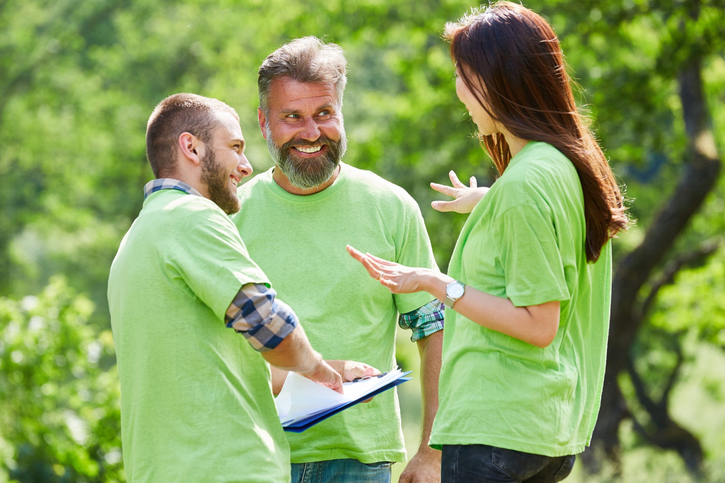 Three volunteer environmental activists at a project meeting in nature