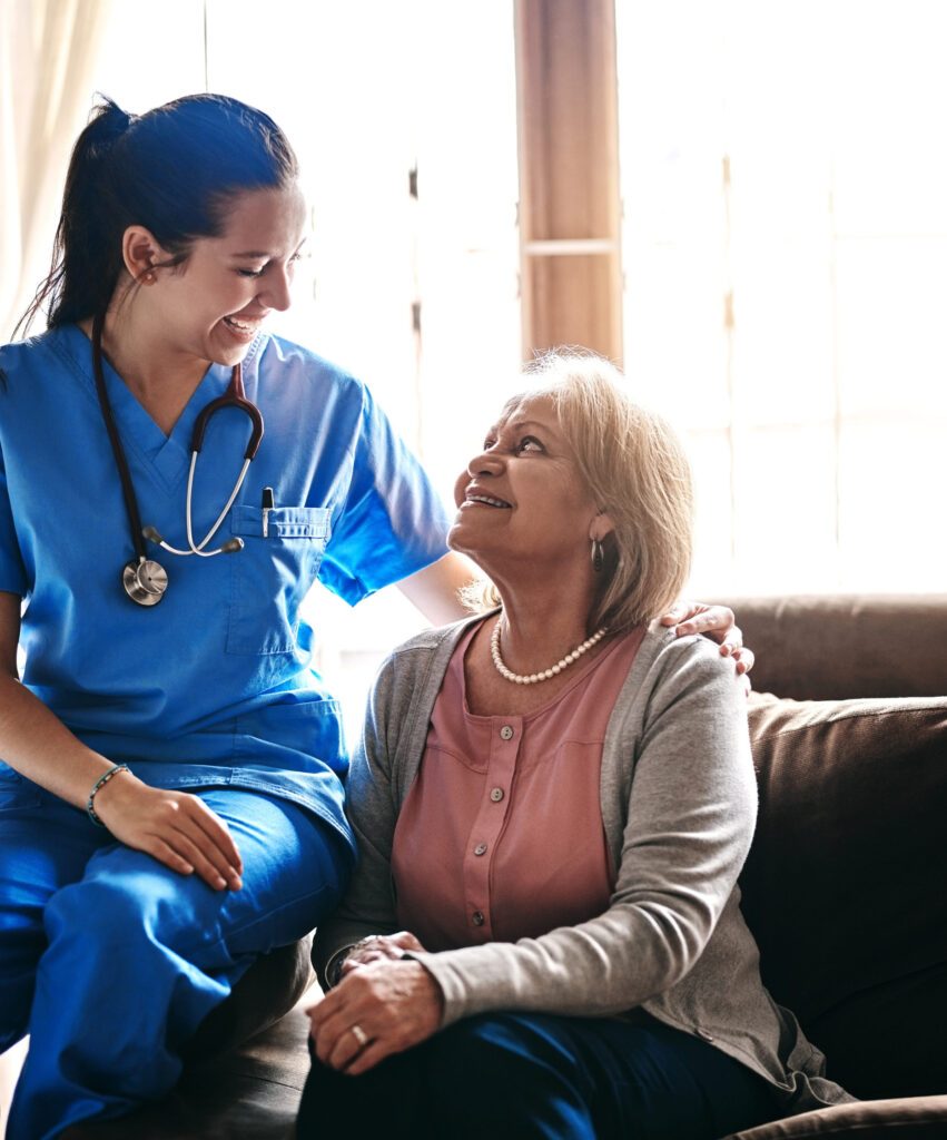 Home care nurse talking with a smiling senior woman