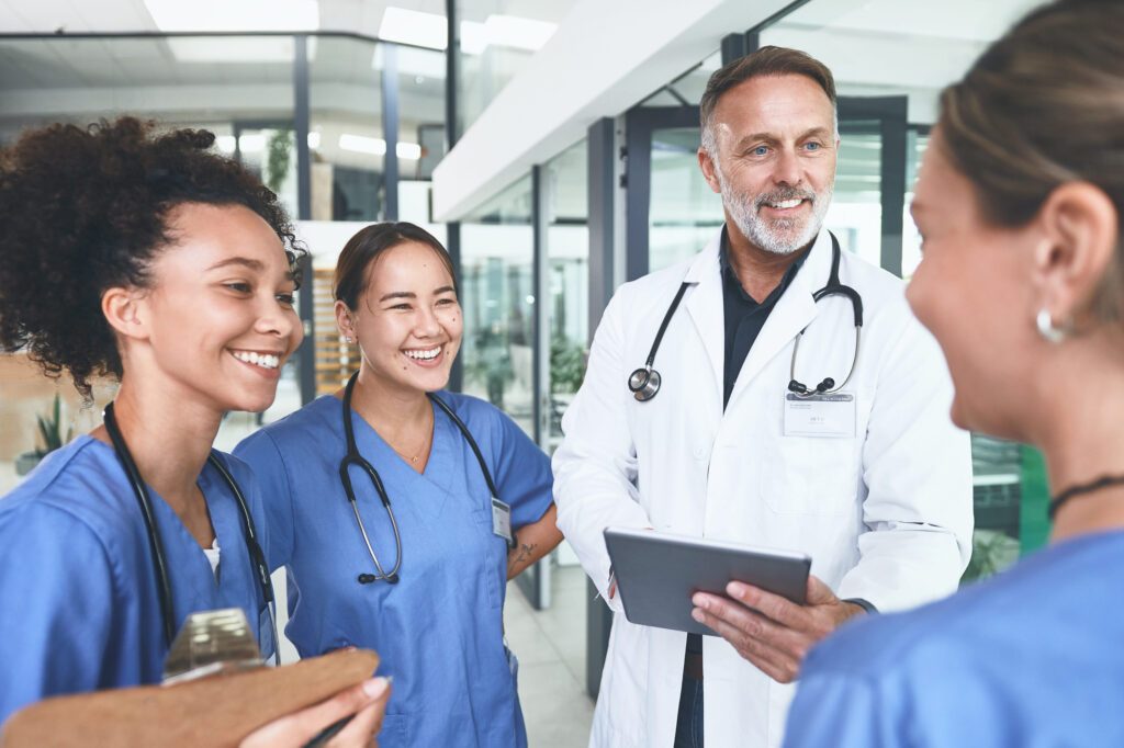 Doctor and nurses reviewing a tablet in a hospital hallway